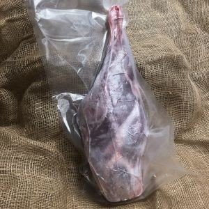 Vakuumpakket lammelår på lyst tekstil